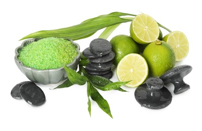 Photo of Spa composition with fresh limes, sea salt, massage stones and bamboo leaves isolated on white