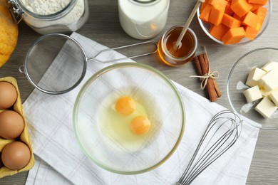 Photo of Different ingredients for pumpkin pancakes on wooden table, flat lay