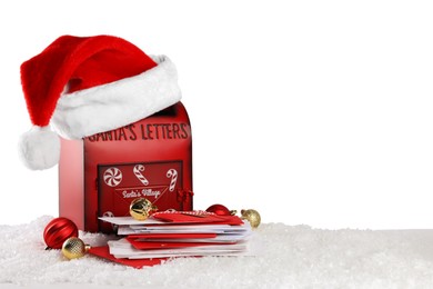 Photo of Santa Claus mail box with hat, letters and Christmas baubles on artificial snow against white background, space for text