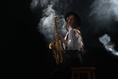 Photo of Professional musician playing saxophone on dark background with smoke