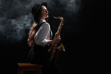 Photo of Professional musician playing saxophone on dark background with smoke