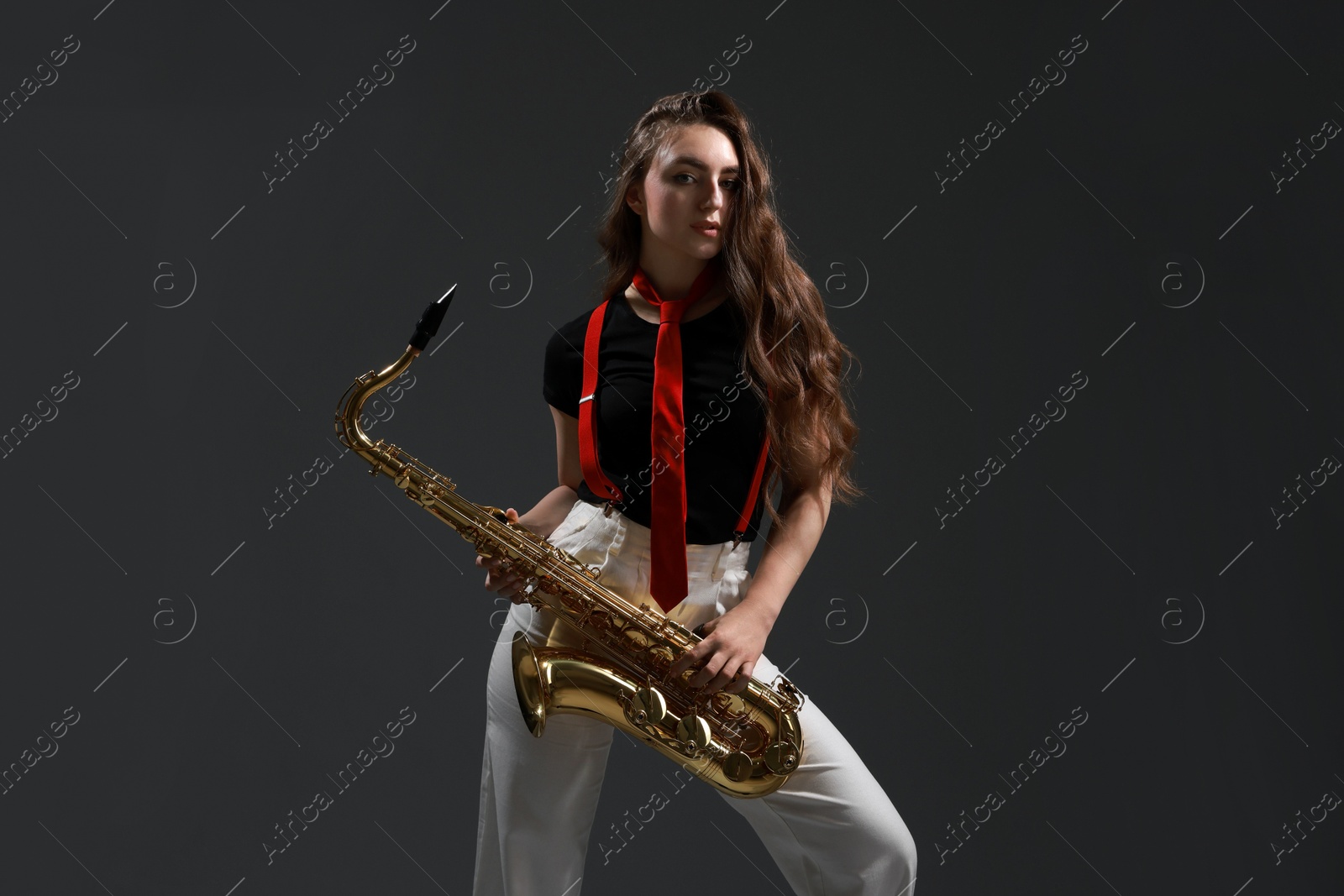 Photo of Professional musician with saxophone on grey background