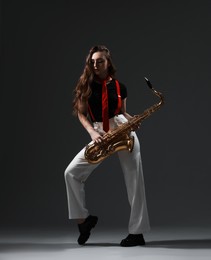 Photo of Professional musician with saxophone on grey background