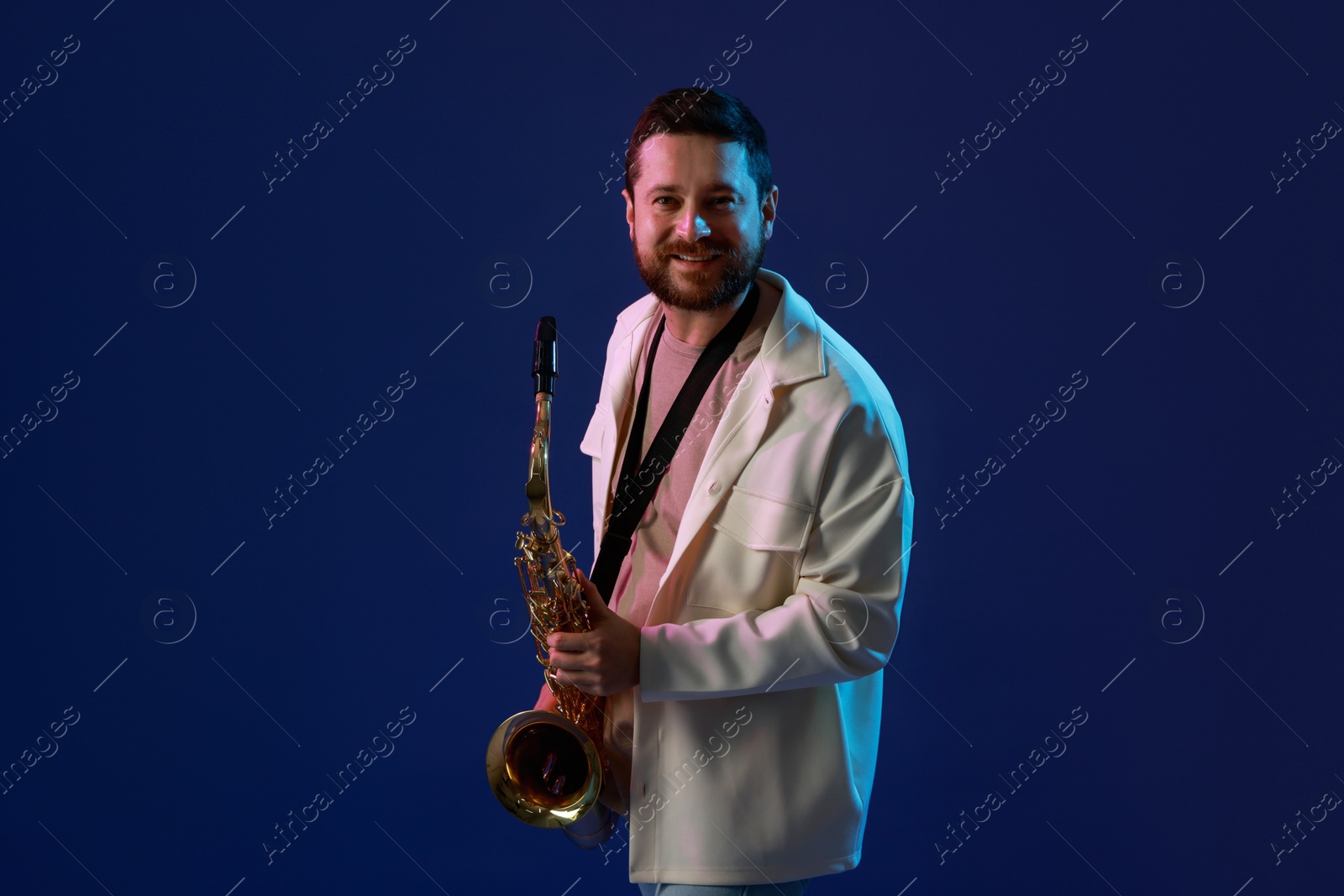 Photo of Professional musician with saxophone on blue background