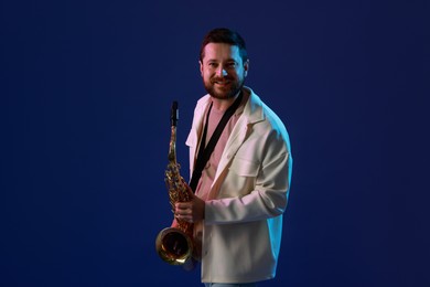 Photo of Professional musician with saxophone on blue background