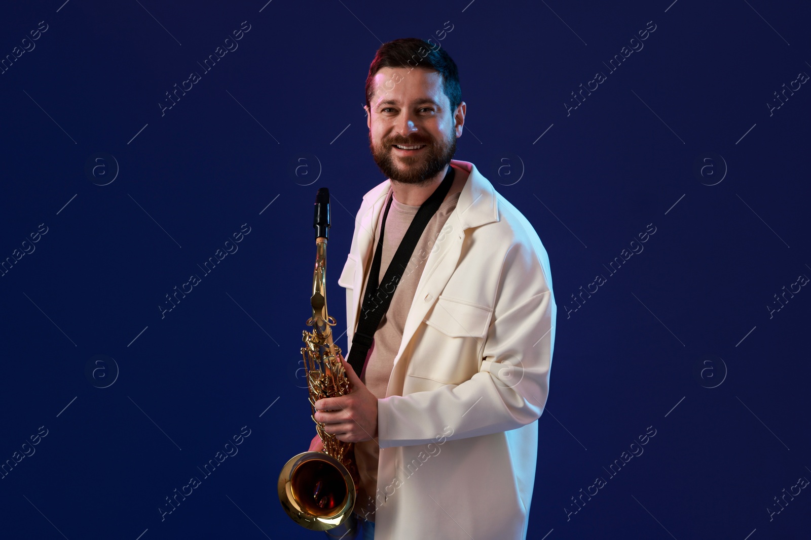 Photo of Professional musician with saxophone on blue background