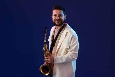 Professional musician with saxophone on blue background