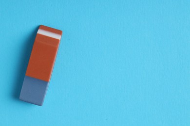 Photo of One eraser on light blue background, top view. Space for text