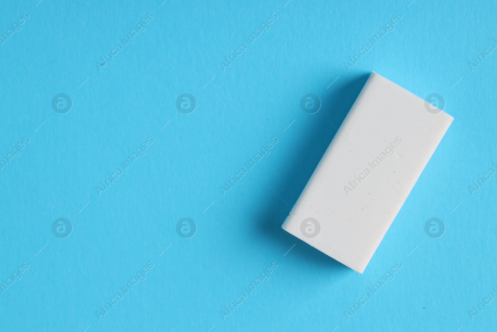 Photo of One eraser on light blue background, top view. Space for text