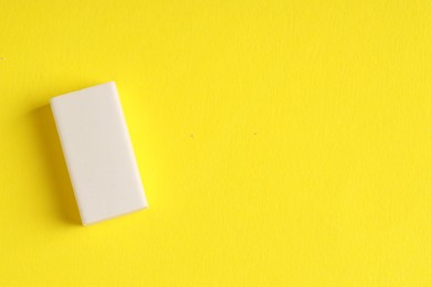 Photo of One eraser on yellow background, top view. Space for text