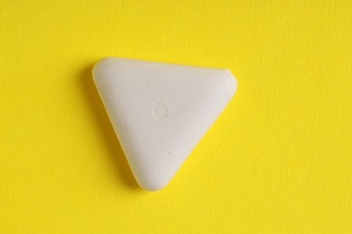 Photo of One eraser on yellow background, top view