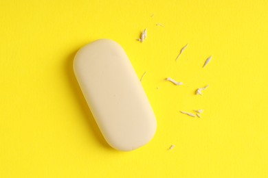 One eraser and scraps on yellow background, top view