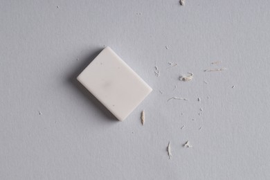 One eraser and scraps on grey background, top view