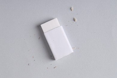 Photo of One eraser and scraps on grey background, top view