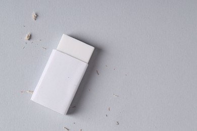 Photo of One eraser and scraps on grey background, top view. Space for text