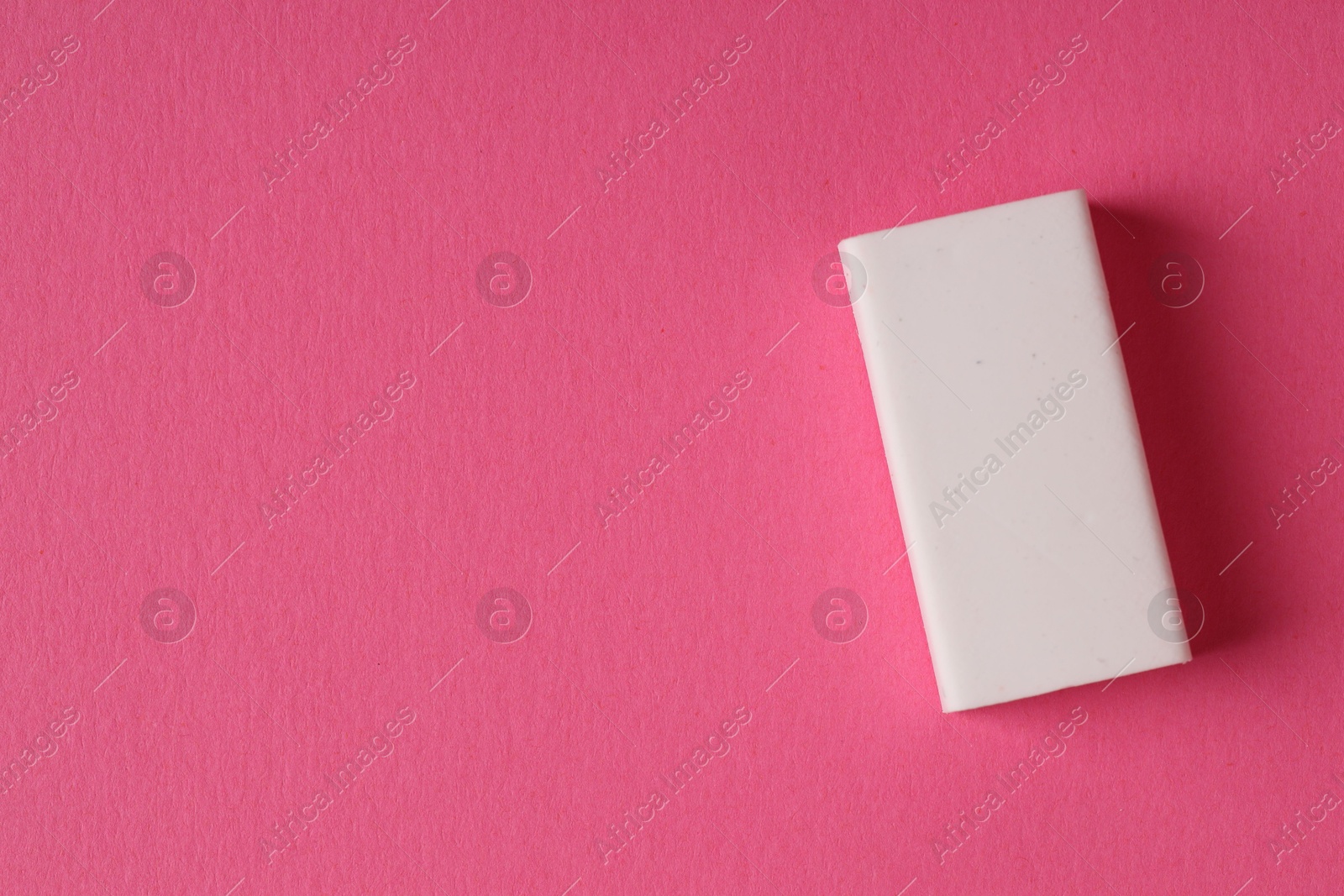 Photo of One eraser on pink background, top view. Space for text