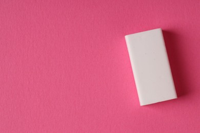 One eraser on pink background, top view. Space for text