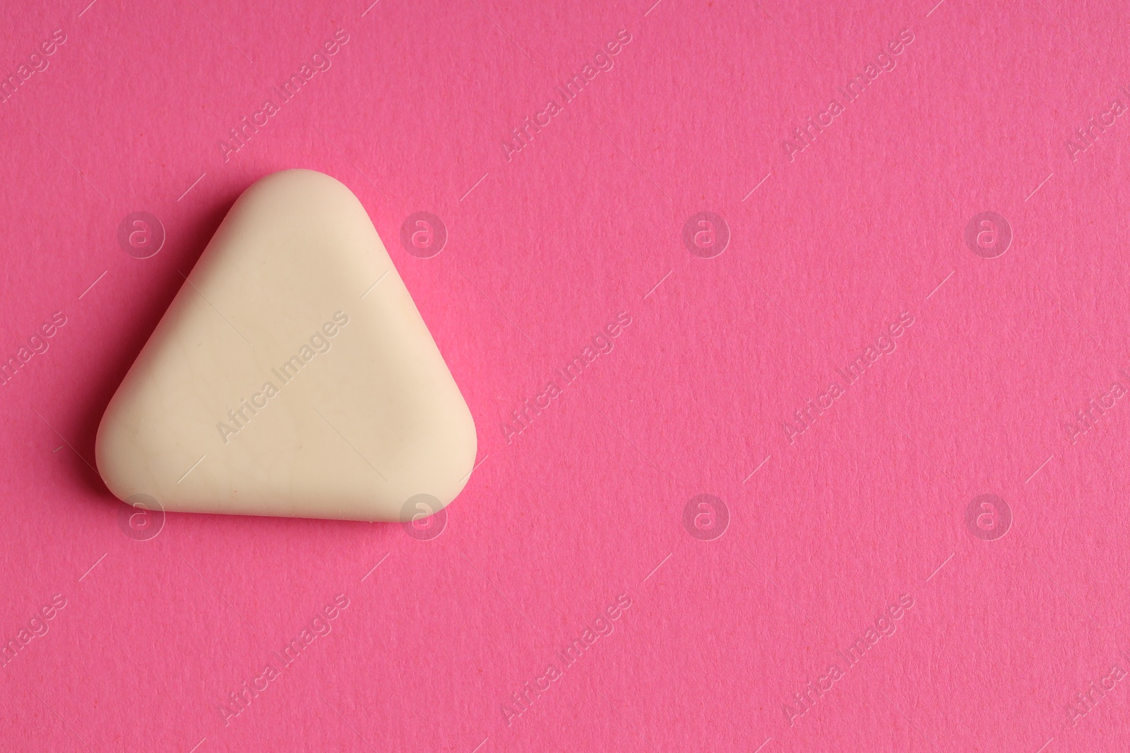 Photo of One eraser on pink background, top view. Space for text