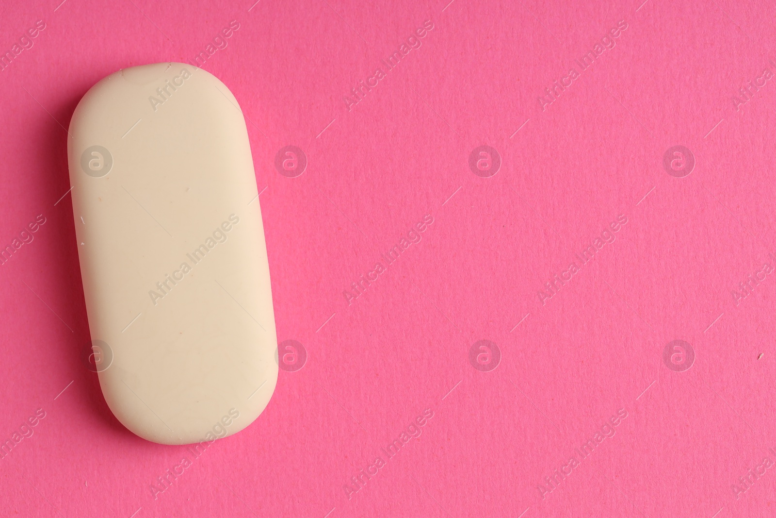 Photo of One eraser on pink background, top view. Space for text