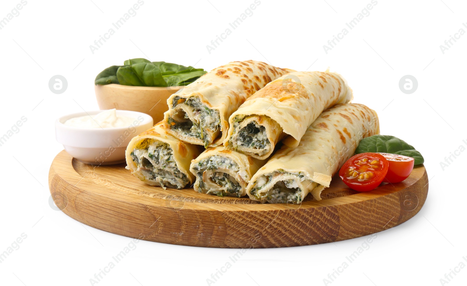 Photo of Tasty rolled crepes with cottage cheese, spinach and tomato isolated on white