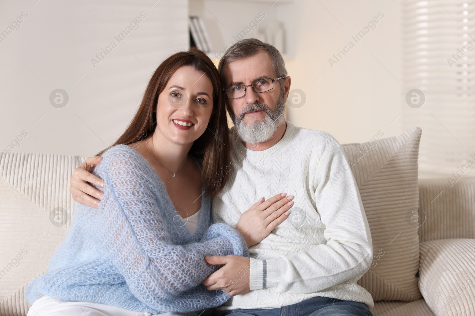 Photo of Family portrait of happy daughter and her father on sofa at home