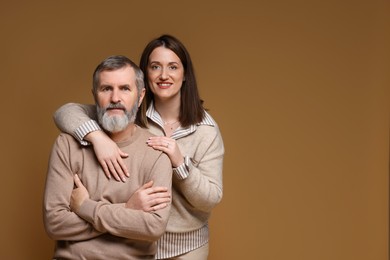 Photo of Family portrait of happy daughter and her father on brown background, space for text