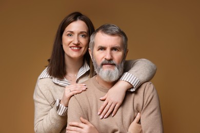 Photo of Family portrait of happy daughter and her father on brown background