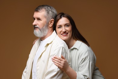 Photo of Happy daughter and her father on brown background