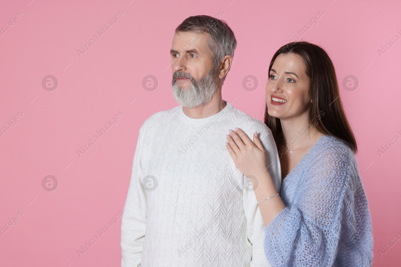 Photo of Happy daughter and her father on pink background, space for text