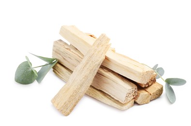 Photo of Palo santo sticks and eucalyptus leaves isolated on white