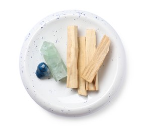 Photo of Palo santo sticks and gemstones isolated on white, top view