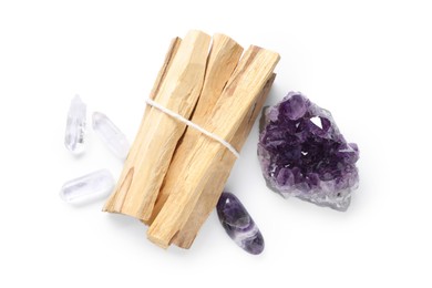 Photo of Palo santo sticks and gemstones isolated on white, top view