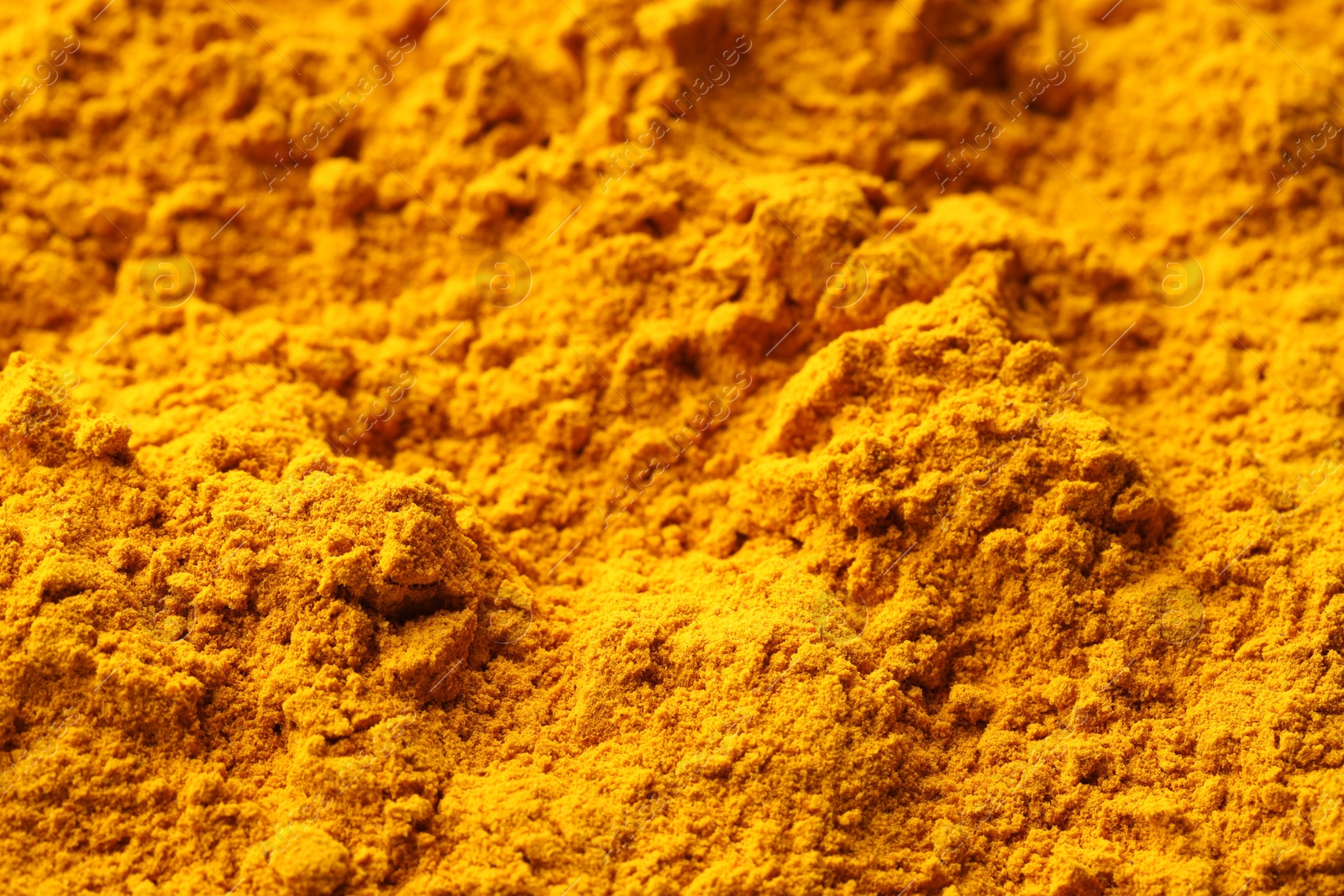 Photo of Aromatic turmeric powder as background, closeup view