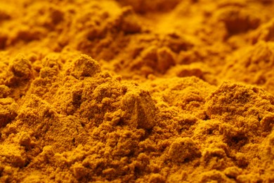 Photo of Aromatic turmeric powder as background, closeup view