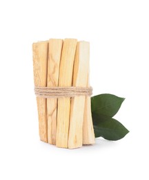 Photo of Bunch of palo santo sticks and green leaves on white background