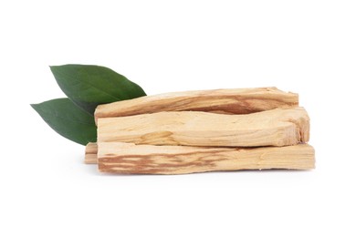 Pile of palo santo sticks and green leaves on white background