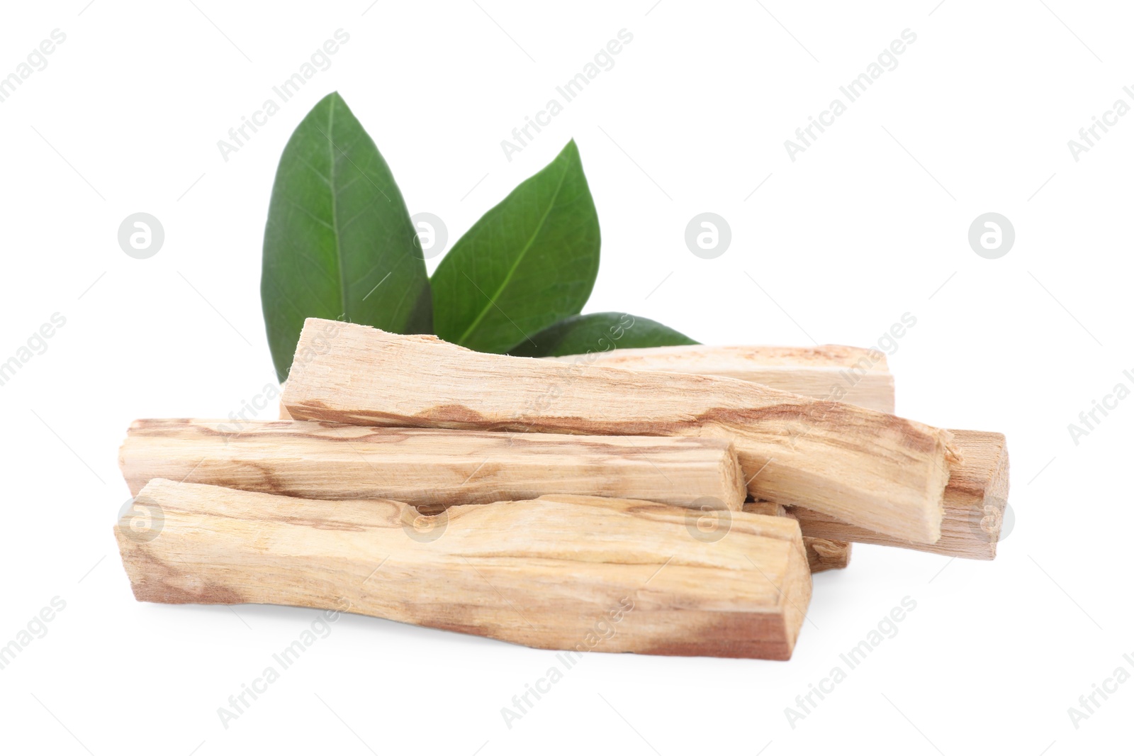 Photo of Pile of palo santo sticks and green leaves on white background