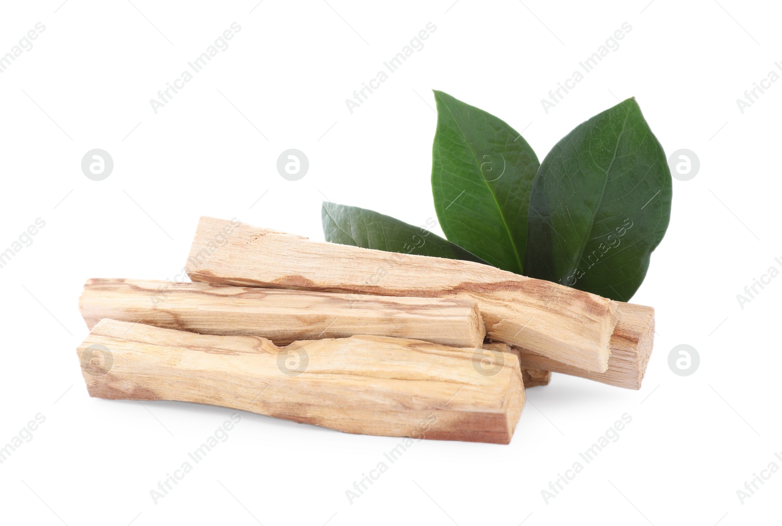 Photo of Pile of palo santo sticks and green leaves on white background