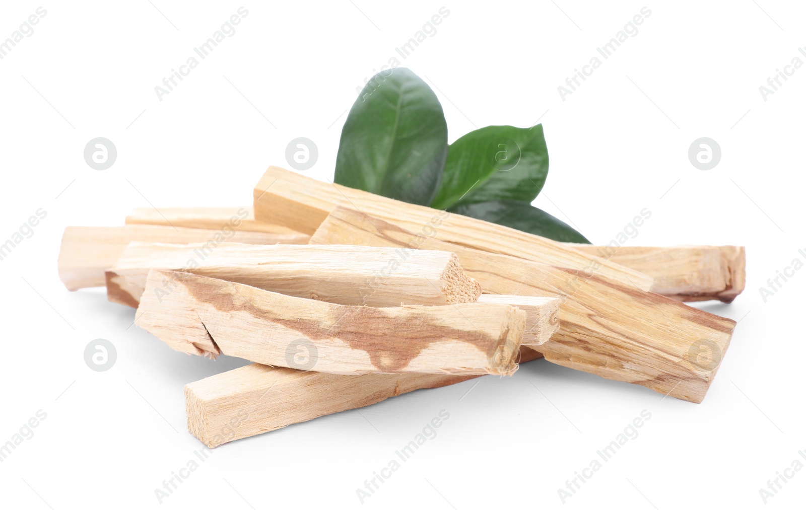 Photo of Pile of palo santo sticks and green leaves on white background