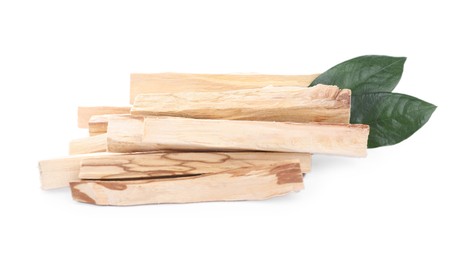 Pile of palo santo sticks and green leaves on white background