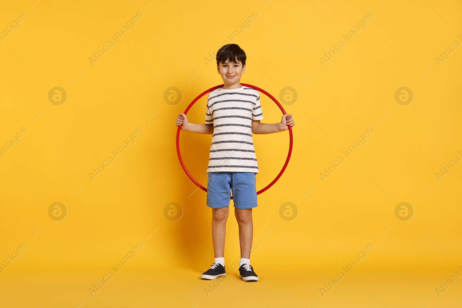 Photo of Boy with hula hoop on yellow background