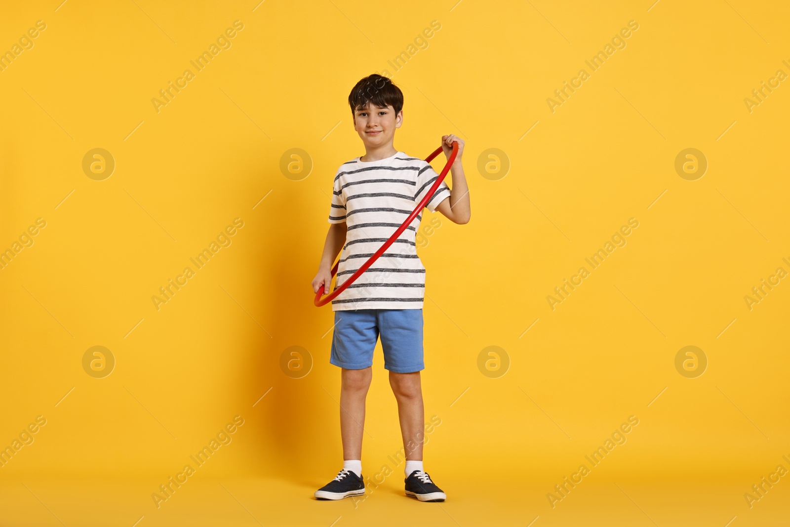 Photo of Boy with hula hoop on yellow background