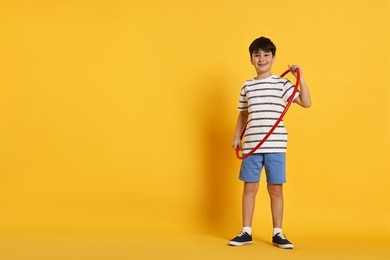 Photo of Smiling boy with hula hoop on yellow background, space for text