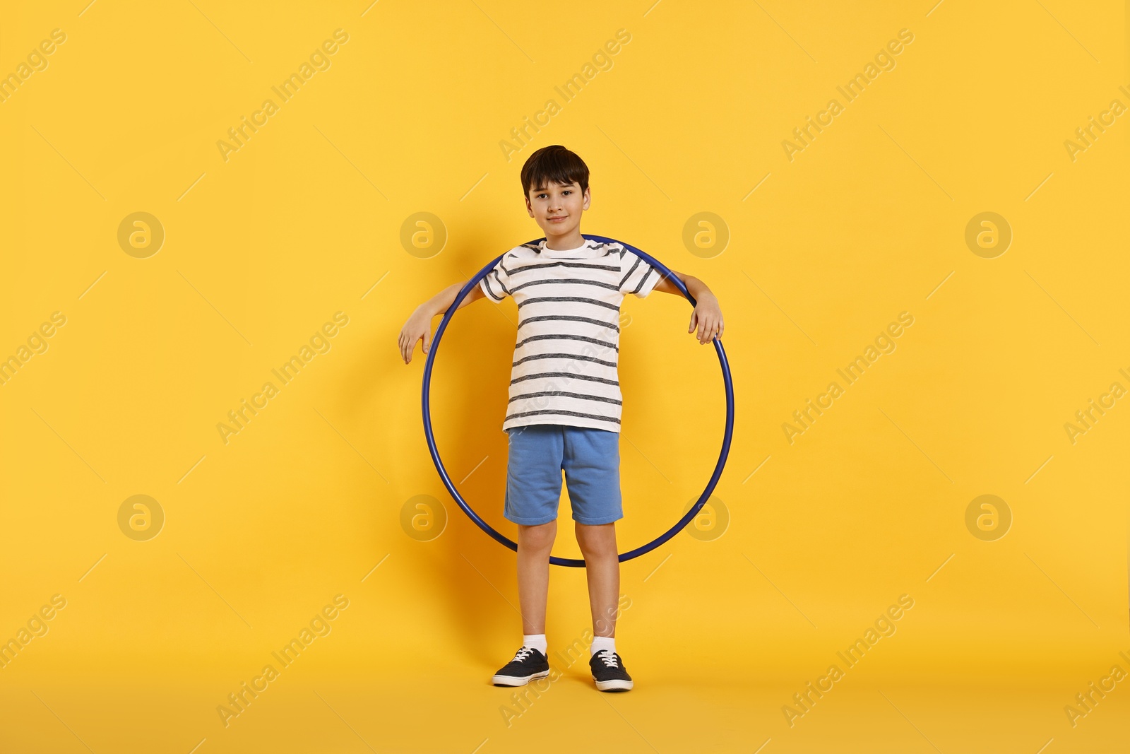 Photo of Boy with hula hoop on yellow background