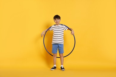 Photo of Boy with hula hoop on yellow background