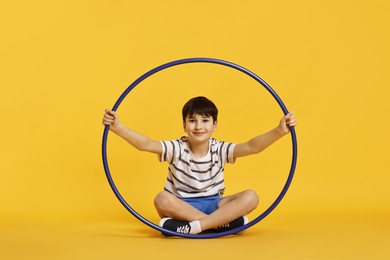 Photo of Boy with hula hoop on yellow background