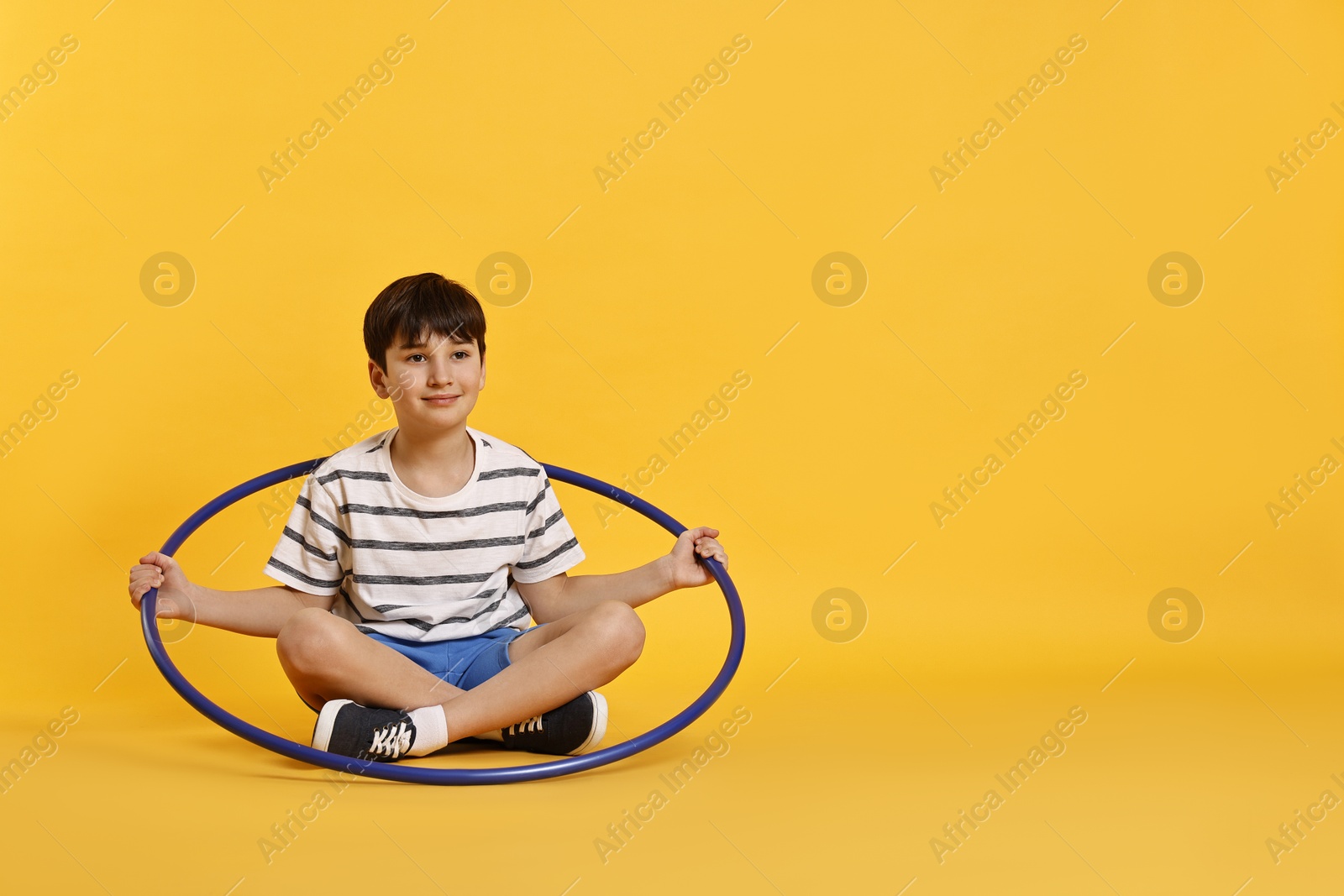 Photo of Boy with hula hoop on yellow background, space for text