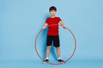 Photo of Boy with hula hoop on light blue background