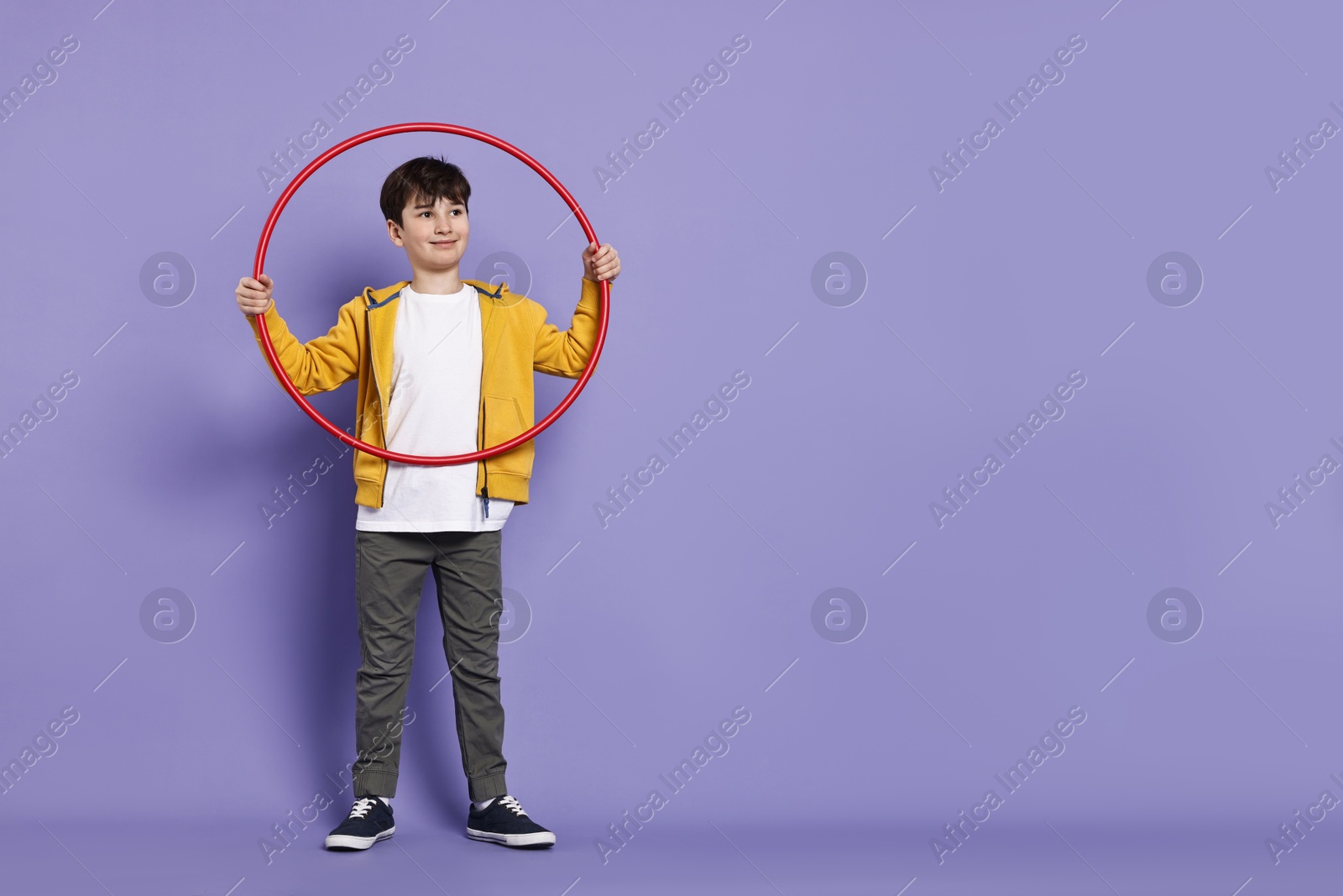 Photo of Boy with hula hoop on violet background, space for text