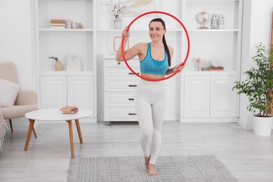 Photo of Smiling woman with hula hoop at home